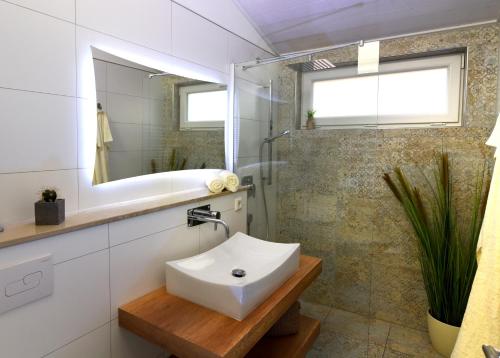 a white bathroom with a sink and a shower at PETIT-CHALET AM HAINER SEE in Rötha