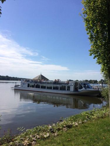 a boat on the water with people on it at Ferienwohnungen am Ruppiner See und Fontane Therme in Neuruppin