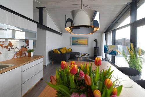 a kitchen and living room with a table with tulips at PETIT-CHALET AM HAINER SEE in Rötha