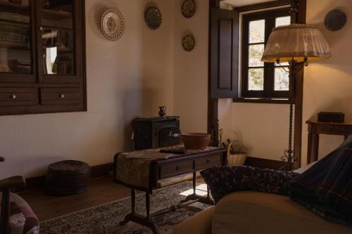 a living room with a couch and a table with a stove at Casa Rústica in Serra do Bouro