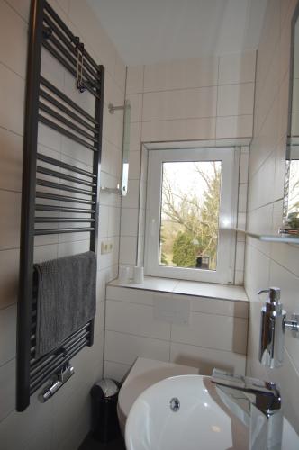 a white bathroom with a sink and a window at Gästehaus Fährmann in Vehra