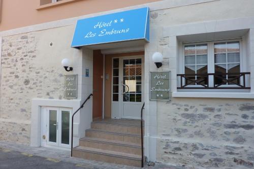 a store with a blue sign on the front of a building at Hôtel Les Embruns Sables d'Olonne in Les Sables-dʼOlonne