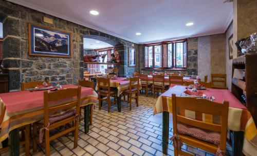 un restaurante con mesas y sillas en una habitación en Hostal Peña Santa en Soto
