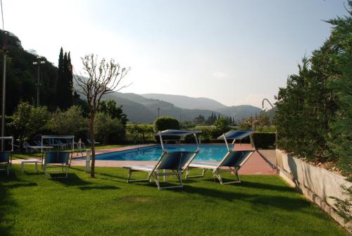 a swimming pool with lounge chairs in a yard at Hotel La Pergola in Grezzana