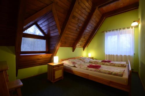 1 dormitorio con cama y techo de madera en Salas-Partizanske, en Partizánske