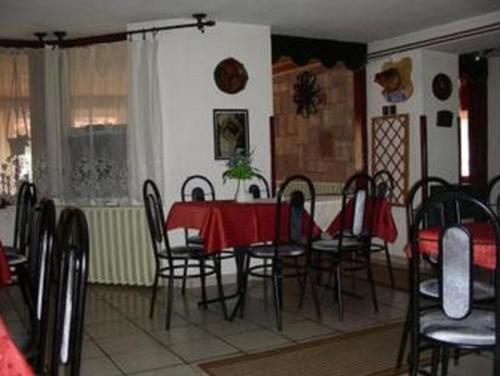 a dining room with a red table and chairs at Lillafüred Kapuja Hotel in Miskolc