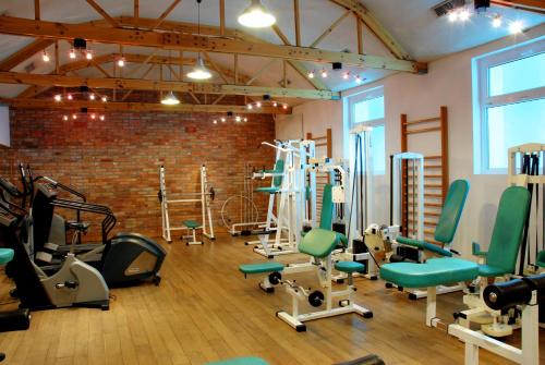 a gym with green chairs and a brick wall at Grand Hotel Ukraine in Dnipro