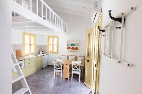 a kitchen and dining room with a table and chairs at Aegli Apartments in Symi