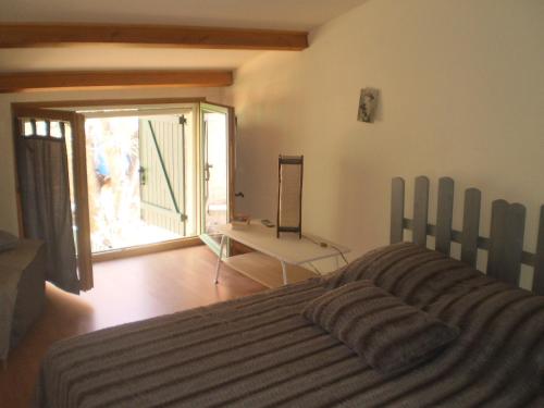 une chambre avec un lit et une porte coulissante en verre dans l'établissement ic locations, à Riez