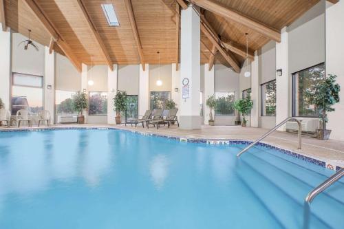 a large pool with blue water in a building at Days Inn & Suites by Wyndham Brinkley in Brinkley