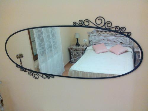 a mirror on a wall with a bed in a room at Toño el Alguacil in Selaya