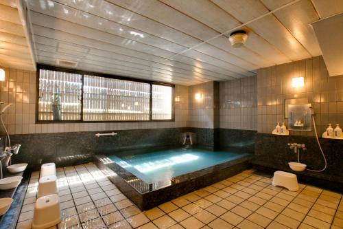 a large bathroom with a large tub in the middle at Yamatoya Honten Ryokan Osaka in Osaka