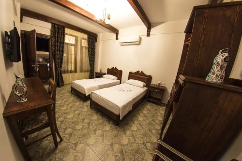 a hotel room with two beds and a table at Hotel Mary's House in Selcuk
