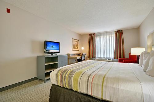 Кровать или кровати в номере Country Inn & Suites By Radisson, Charleston North, SC