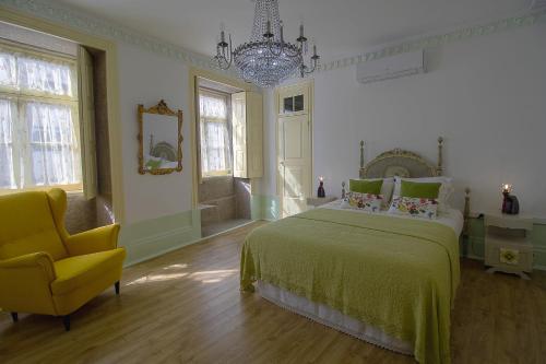 a bedroom with a bed and a yellow chair at HC Villa Douro in Vila Nova de Gaia