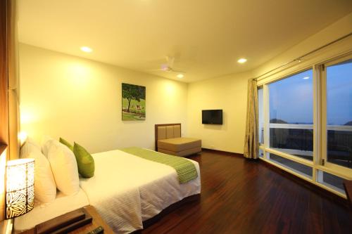 a bedroom with a bed and a large window at Sterling Ooty Fern Hill in Ooty