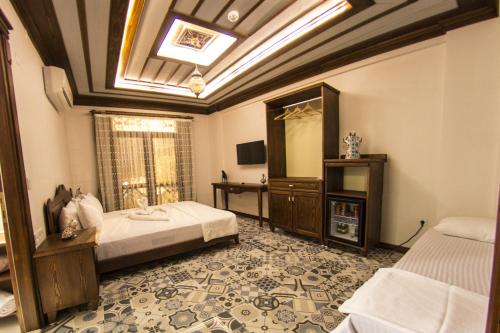 a room with two beds and a television in it at Hotel Mary's House in Selcuk