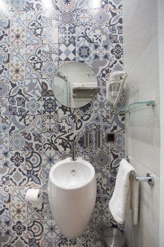 a bathroom with a sink and blue and white tiles at La Sepia Boba (Adults only) in Peñíscola