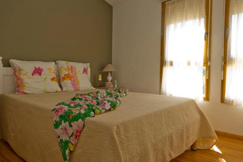 Un dormitorio con una cama grande con una manta. en Résidence Goélia Le Domaine du Moulin Blanc, en Gordes