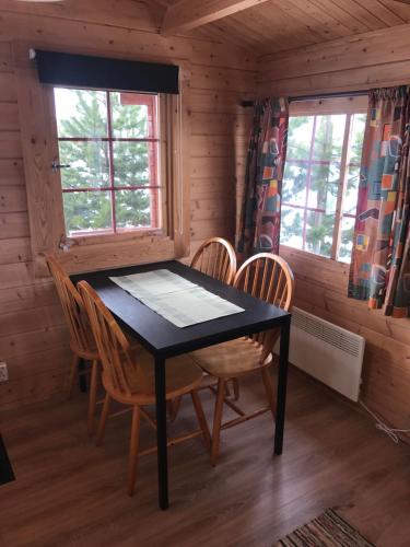 a dining room with a table and chairs in a cabin at Stora Sandfell Rooms and Cottages in Stóra-Sandfell