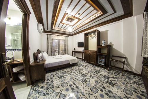 a bedroom with a bed and a bathroom with a ceiling at Hotel Mary's House in Selçuk