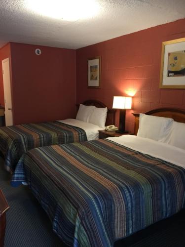 - 2 lits dans une chambre d'hôtel aux murs rouges dans l'établissement Hope Inn, à Lenox