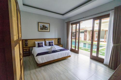 1 dormitorio con 1 cama y balcón con piscina en Toya Villa Ubud, en Ubud