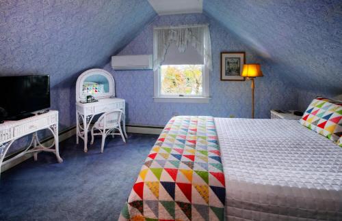 een slaapkamer met een bed, een televisie en een raam bij Luther Ogden Inn in Cape May