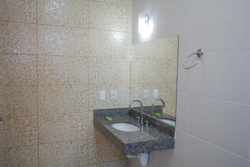 a bathroom with a sink and a tiled wall at Hotel Real São Lourenço in São Lourenço