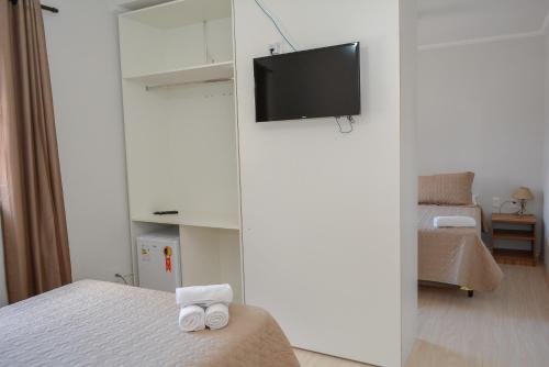 a bedroom with two beds and a tv on a wall at Hotel Real São Lourenço in São Lourenço