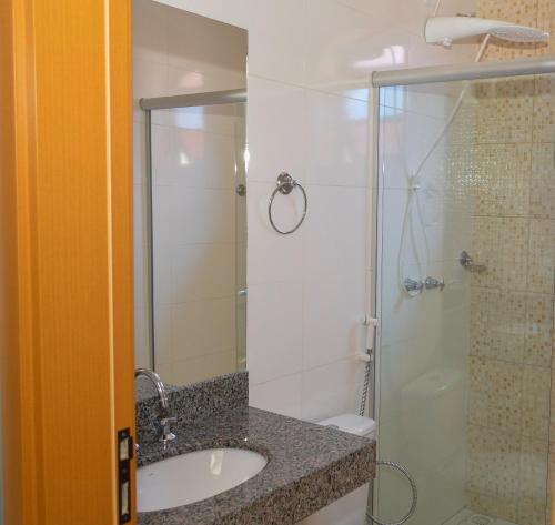a bathroom with a sink and a shower at Hotel Real São Lourenço in São Lourenço