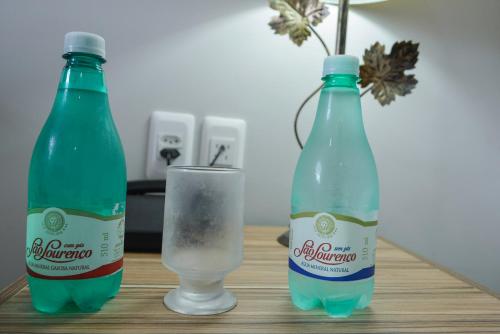 two bottles and a glass of water on a table at Hotel Real São Lourenço in São Lourenço