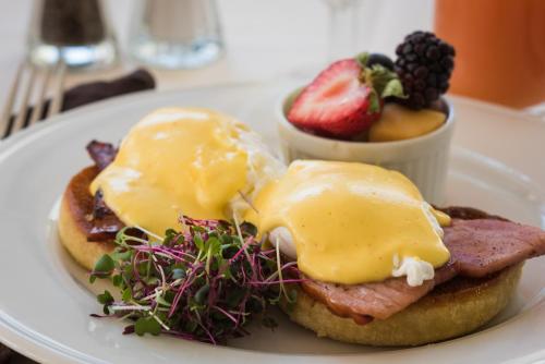 a plate of food with eggs and ham and a bowl of fruit at The Dorset Inn in Dorset