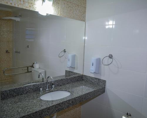 a bathroom with a sink and a mirror at Hotel Real São Lourenço in São Lourenço