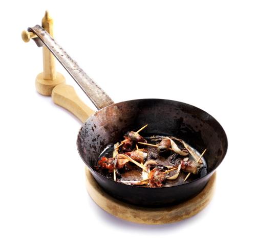 a pan filled with food on a wooden spoon at Pension Lectar in Radovljica