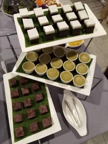two trays of green and yellow desserts on a table at The Bliss Ubon in Ubon Ratchathani