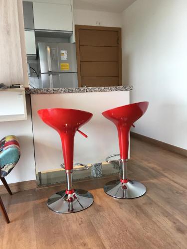 two red bar stools sitting in a kitchen at Anitta 2 in Sao Paulo