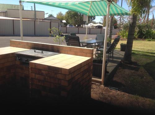 a patio with a table and an umbrella at Charleville Waltzing Matilda Motor Inn in Charleville