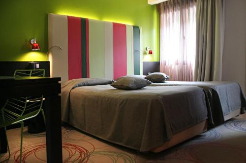 a bedroom with a bed with a colorful wall at Hotel La Pergola in Grezzana