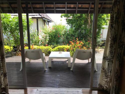 a patio with two chairs and a table and a table at Pension Motu Iti in Pihaena