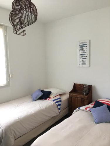 two beds sitting next to each other in a room at Villa L'Amiraute in Agde