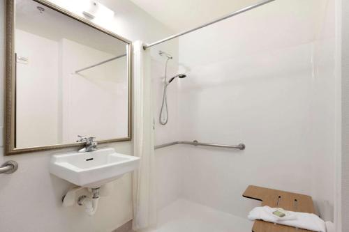 a bathroom with a sink and a mirror at Super 8 by Wyndham Garland Rowlett East Dallas Area in Garland