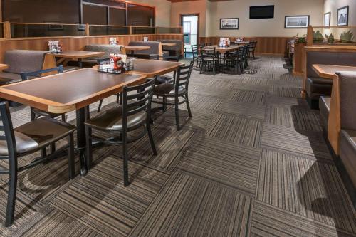 a dining room with tables and chairs in a restaurant at Super 8 by Wyndham Edmonton/West in Edmonton