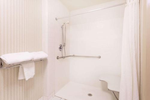 y baño blanco con ducha y aseo. en Super 8 by Wyndham Macon West, en Macon