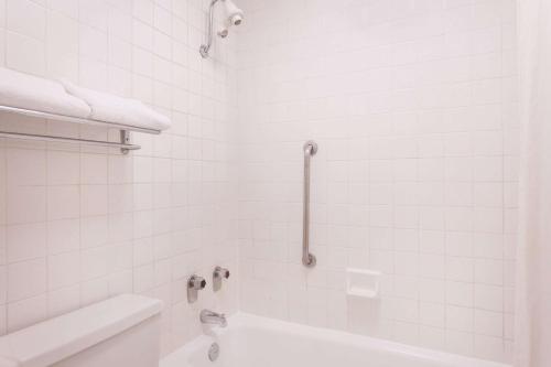 a white bathroom with a tub and a sink at Super 8 by Wyndham Macon West in Macon