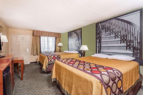 a hotel room with two beds and a staircase at Super 8 by Wyndham Macon West in Macon