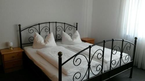 a bedroom with a bed with white sheets and pillows at Hotel Gasthof Ratstube in Kirchheim unter Teck