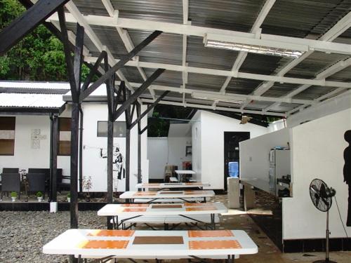un groupe de tables de pique-nique dans un bâtiment dans l'établissement RedDoorz @ Western Highway Lodge Hotel, à Marabut