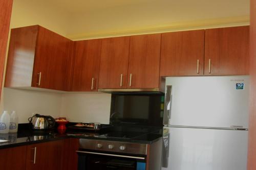 a kitchen with wooden cabinets and a refrigerator at Jasmine Hills Lodge in Doi Saket