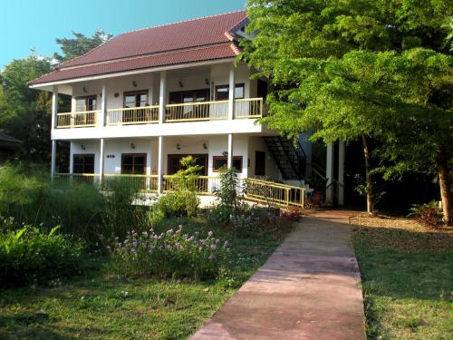 a white house with a walkway in front of it at Jasmine Hills Lodge in Doi Saket